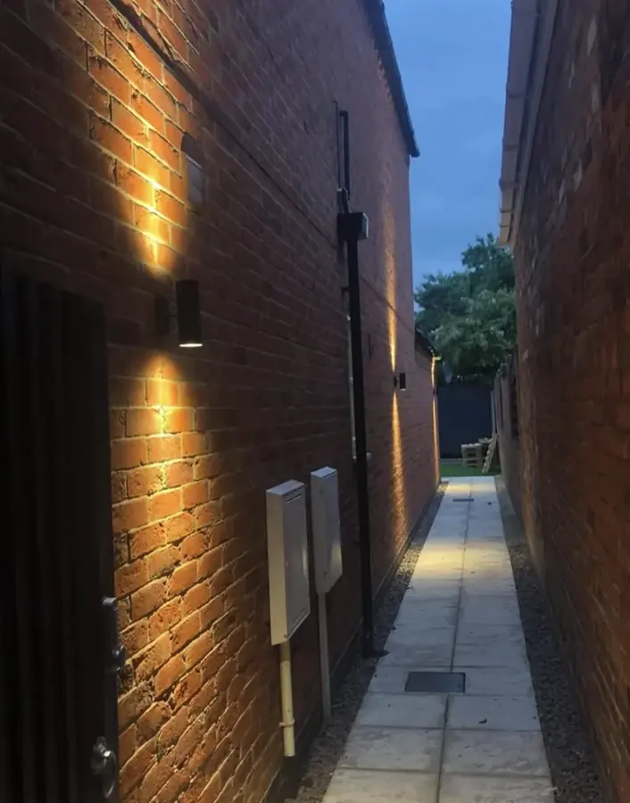 Outside wall lights along a brick passage at dusk in Lincoln