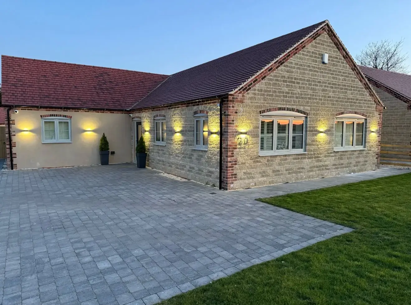 A Lincoln bungalow with the outside lighting on at dusk