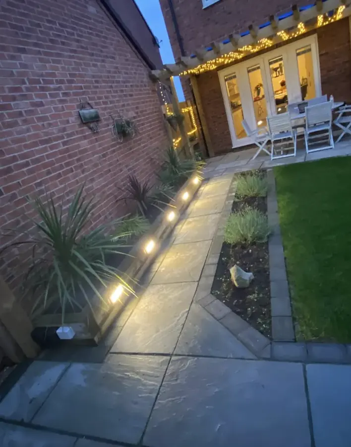 A lit garden path and seating area at dusk