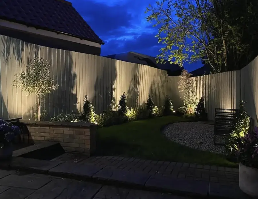 Garden uplighters along a fence at dusk in Lincoln